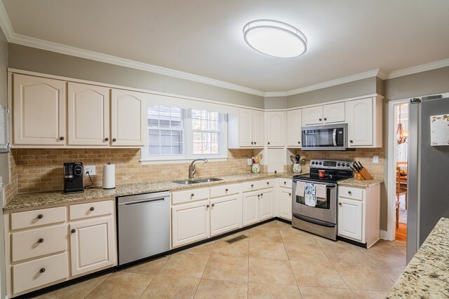816 Dogwood Ln, Dalton, GA 30720 - kitchen with appliances with stainless steel finishes, a sink, ornamental molding, backsplash, and light stone countertops