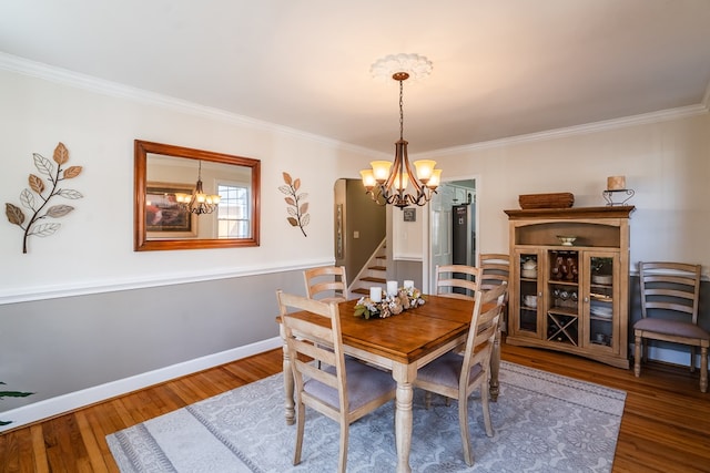 dining room with crown molding, hardwood / wood-style floors, and a chandelier