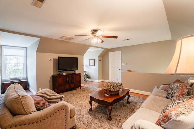 living room featuring ceiling fan, light hardwood / wood-style floors, and vaulted ceiling