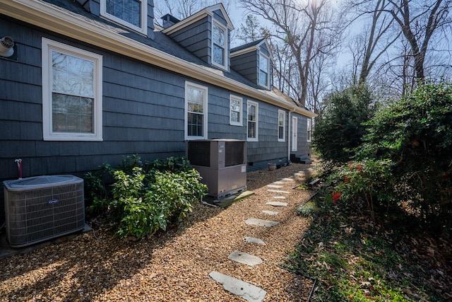 view of side of home with central AC unit