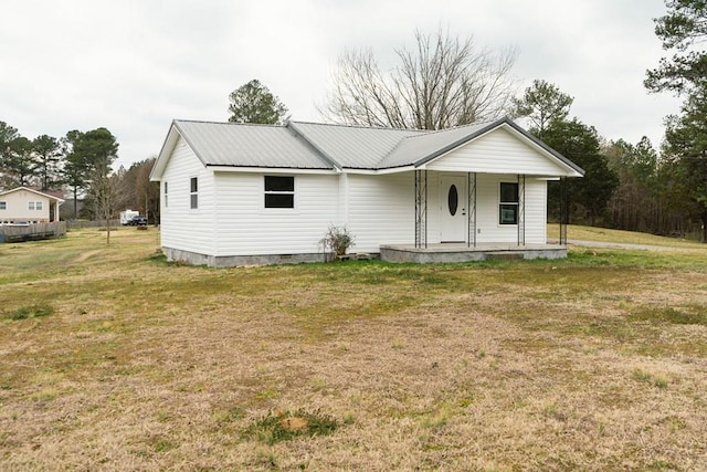 view of front of property featuring crawl space, a porch, metal roof, and a front yard