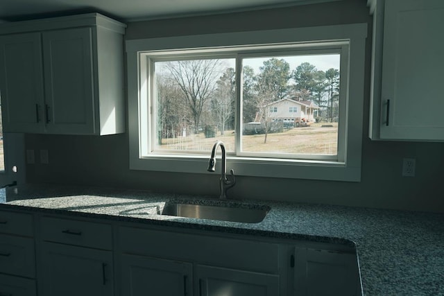 kitchen featuring a sink, a healthy amount of sunlight, and white cabinetry