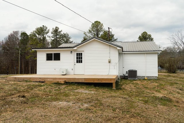 rear view of house with a wooden deck, a lawn, central AC, and metal roof