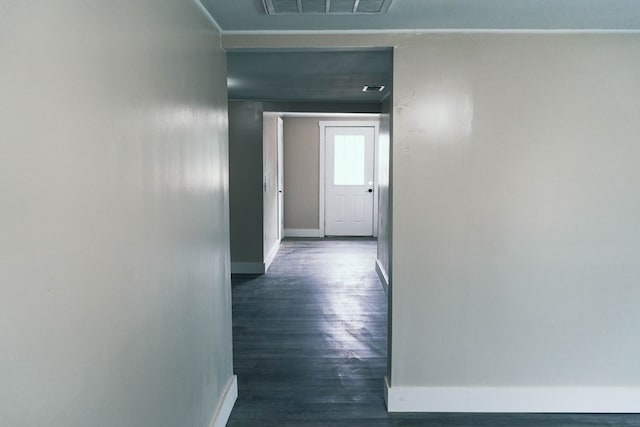 corridor featuring baseboards, visible vents, and dark wood-style flooring