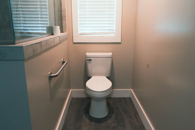 bathroom with toilet, wood finished floors, and baseboards