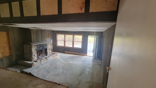 2517 Utility Rd, Rocky Face, GA 30740 - unfurnished living room featuring unfinished concrete floors, a stone fireplace, and wood walls