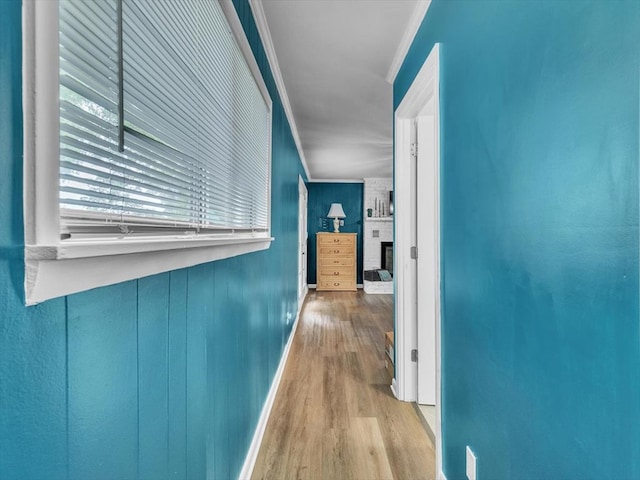 hall with crown molding, wood finished floors, and baseboards