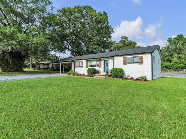 ranch-style home with concrete driveway, an attached carport, a front lawn, and brick siding