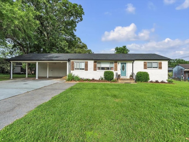 ranch-style home with an attached carport, a front yard, brick siding, and driveway