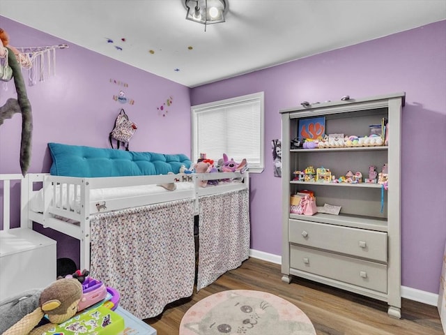 bedroom with wood finished floors and baseboards