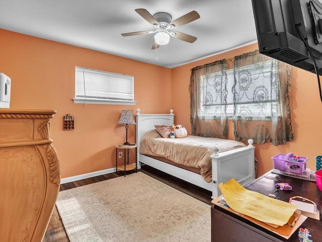 bedroom featuring wood finished floors, baseboards, and ceiling fan