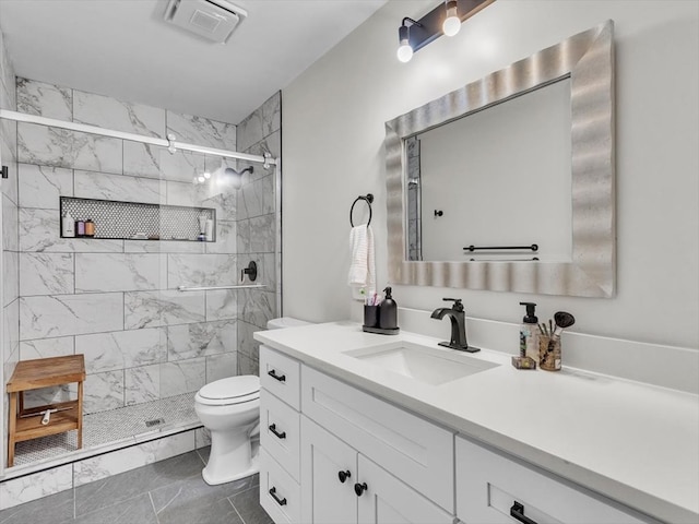 bathroom featuring toilet, a shower stall, and vanity