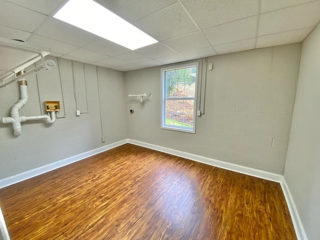 basement with dark hardwood / wood-style floors and a drop ceiling