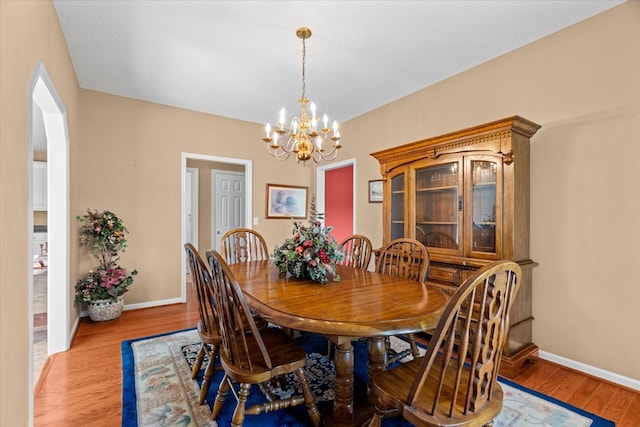 188 Valley Rd, Chatsworth, GA 30705 - dining area featuring a chandelier, arched walkways, and light wood-type flooring