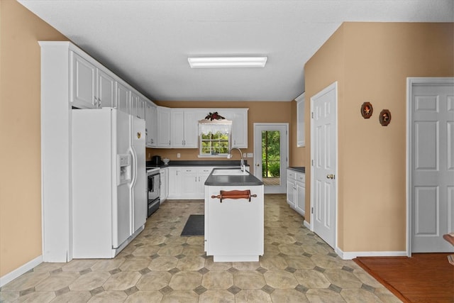 188 Valley Rd, Chatsworth, GA 30705 - kitchen with white refrigerator with ice dispenser, dark countertops, a center island with sink, electric stove, and white cabinets