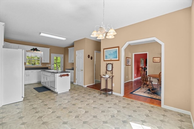 188 Valley Rd, Chatsworth, GA 30705 - kitchen with white appliances, dark countertops, a chandelier, white cabinets, and a center island