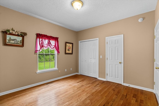 188 Valley Rd, Chatsworth, GA 30705 - unfurnished bedroom featuring light wood-style flooring and a textured ceiling
