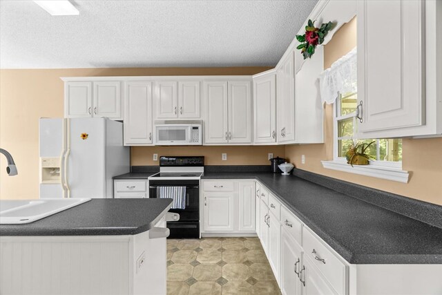 188 Valley Rd, Chatsworth, GA 30705 - kitchen featuring white appliances, dark countertops, white cabinets, and a textured ceiling