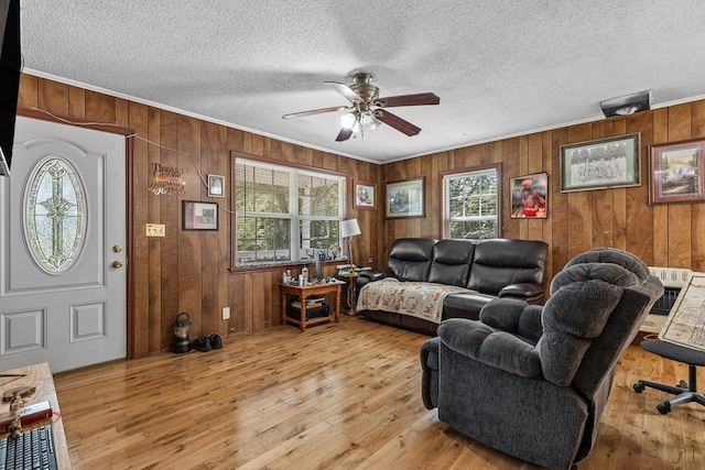 living room with crown molding, a wealth of natural light, light hardwood / wood-style flooring, and ceiling fan