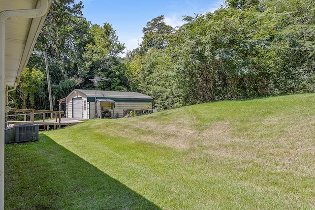 view of yard featuring a storage unit and central AC unit