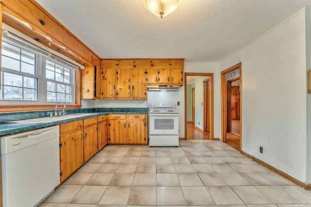 kitchen featuring under cabinet range hood, a textured ceiling, dark countertops, white appliances, and baseboards