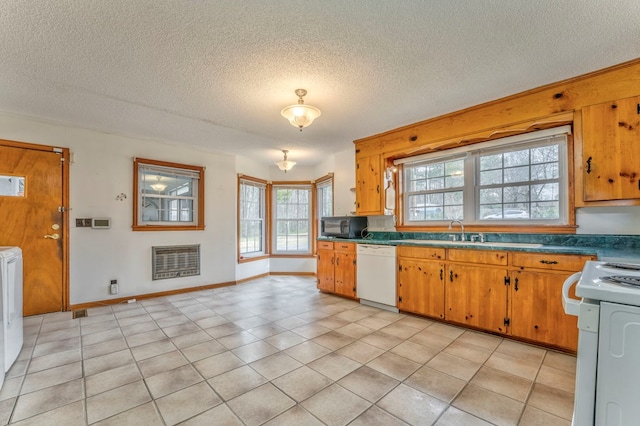 kitchen featuring heating unit, white appliances, a textured ceiling, and brown cabinets