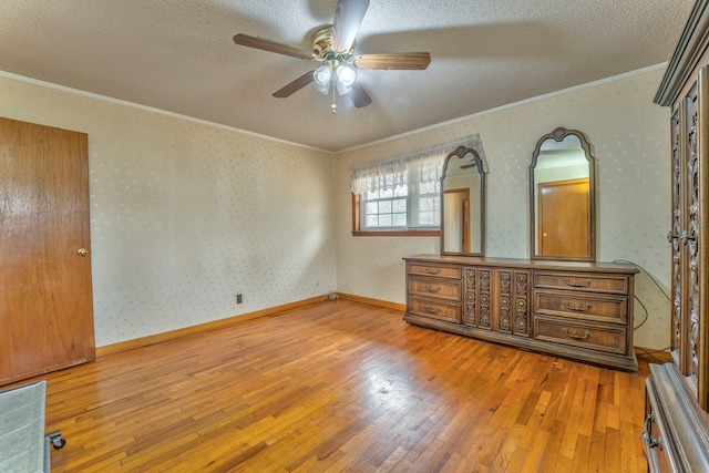 unfurnished bedroom featuring a textured ceiling, hardwood / wood-style flooring, and wallpapered walls