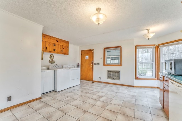 laundry room with baseboards, washing machine and dryer, laundry area, heating unit, and a textured ceiling