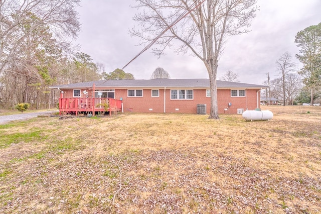 rear view of property featuring brick siding, a wooden deck, cooling unit, a yard, and crawl space