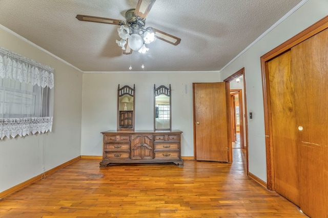 bedroom with baseboards, a textured ceiling, wood finished floors, and crown molding