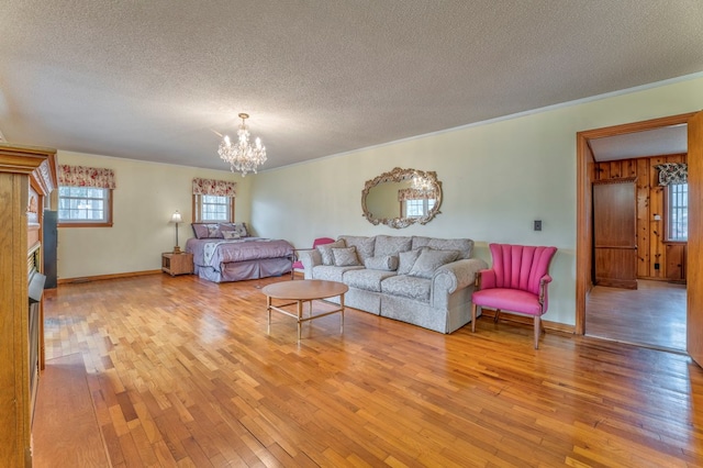 living room featuring a chandelier, a textured ceiling, and light wood-style floors