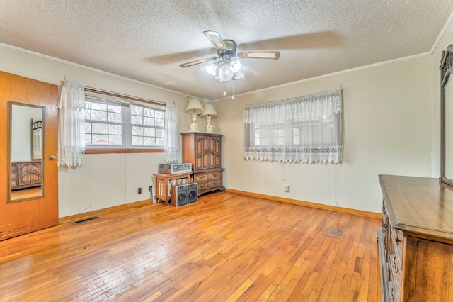 interior space featuring visible vents, ornamental molding, a textured ceiling, and hardwood / wood-style floors