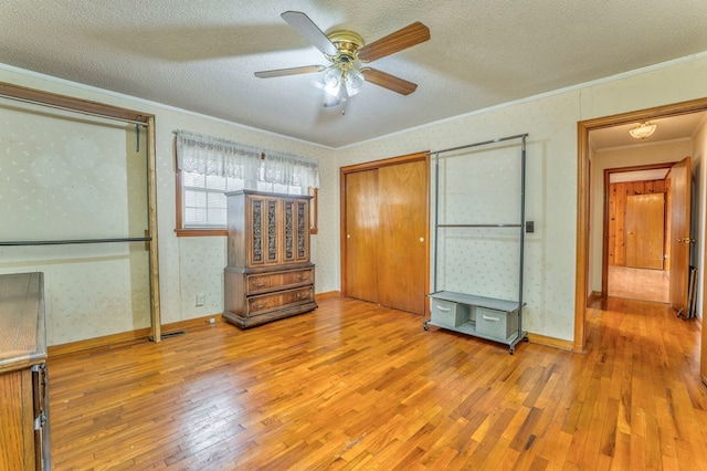 bedroom featuring wallpapered walls, a textured ceiling, crown molding, and hardwood / wood-style floors