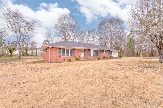 single story home featuring brick siding and an attached garage