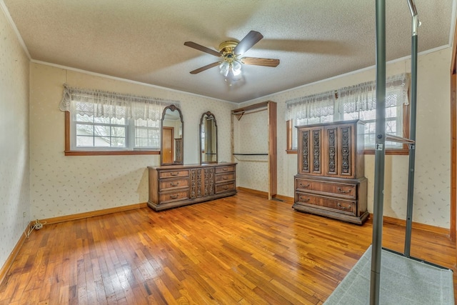 bedroom featuring wallpapered walls, ornamental molding, hardwood / wood-style floors, and a textured ceiling