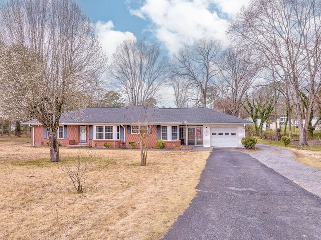 ranch-style home with brick siding, an attached garage, and driveway