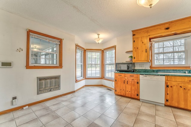 kitchen with a wealth of natural light, black microwave, heating unit, and white dishwasher