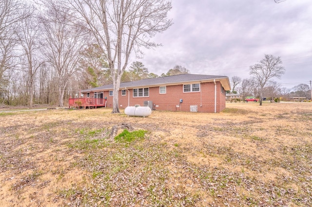 rear view of house with crawl space, brick siding, and a deck