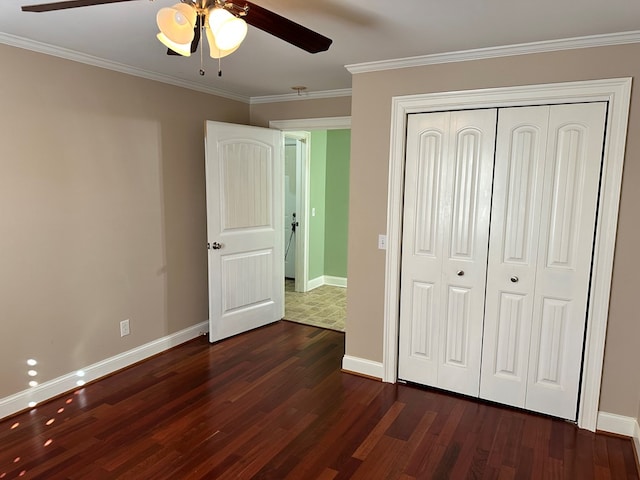 unfurnished bedroom featuring crown molding, dark wood-type flooring, and a closet