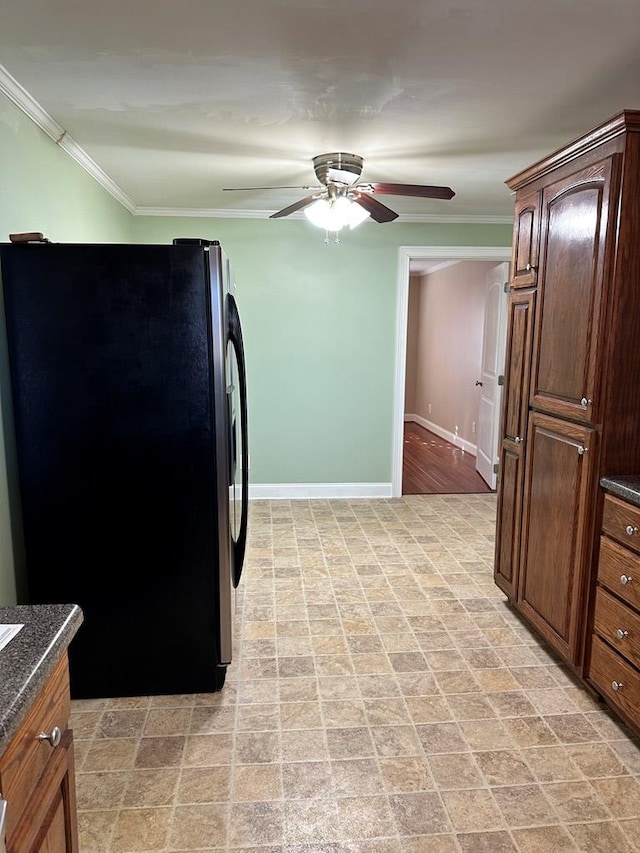 kitchen with ceiling fan, ornamental molding, and stainless steel fridge