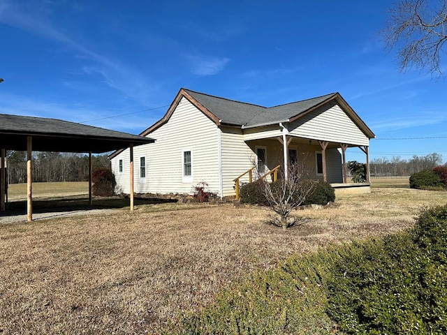 view of side of property with a carport, a porch, and a lawn