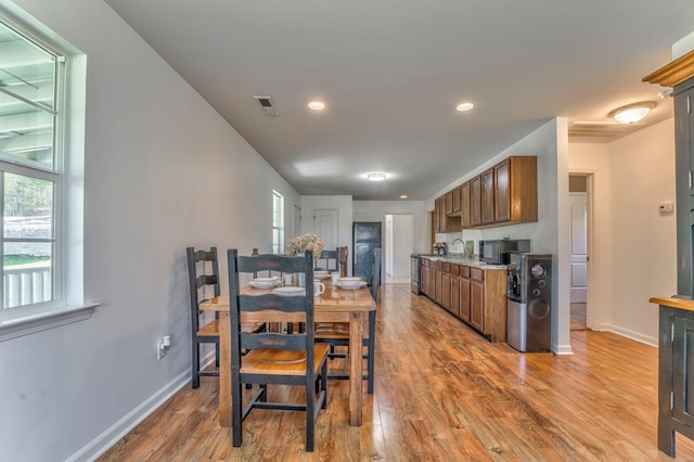 kitchen with black microwave, visible vents, baseboards, and wood finished floors