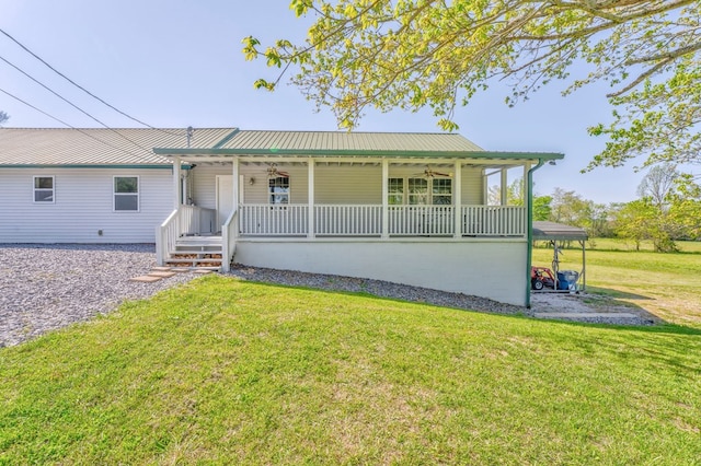 single story home with metal roof, a ceiling fan, a front yard, and covered porch