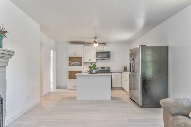 kitchen featuring a center island, a ceiling fan, white cabinetry, light wood finished floors, and appliances with stainless steel finishes