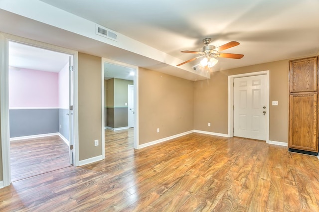 empty room with baseboards, visible vents, light wood-style floors, and ceiling fan