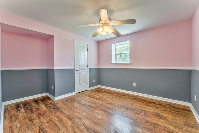 unfurnished room featuring hardwood / wood-style floors, baseboards, and ceiling fan
