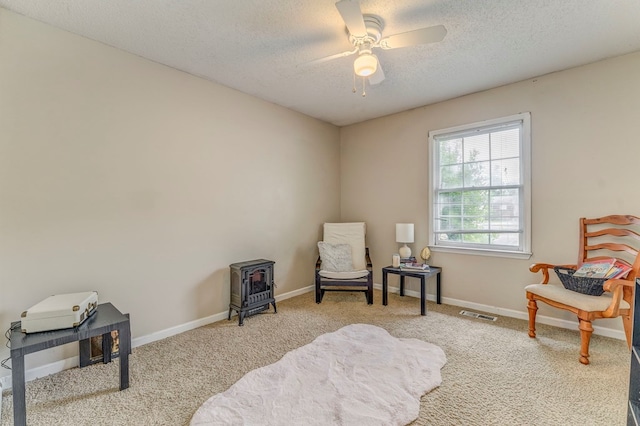 1962 Meadowbrook Cir, Dalton, GA 30720 - living area featuring a wood stove, carpet, a ceiling fan, and a textured ceiling