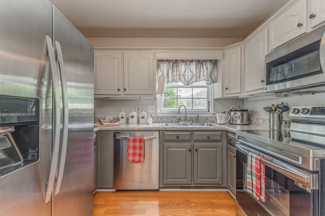 1962 Meadowbrook Cir, Dalton, GA 30720 - kitchen featuring appliances with stainless steel finishes, gray cabinetry, light wood-type flooring, and white cabinets