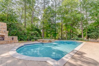 1603 Habersham Way, Dalton, GA 30720 - view of swimming pool featuring a patio area, an outdoor stone fireplace, and a pool with connected hot tub