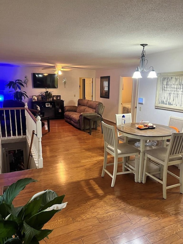 dining room with an inviting chandelier, hardwood / wood-style flooring, and a textured ceiling